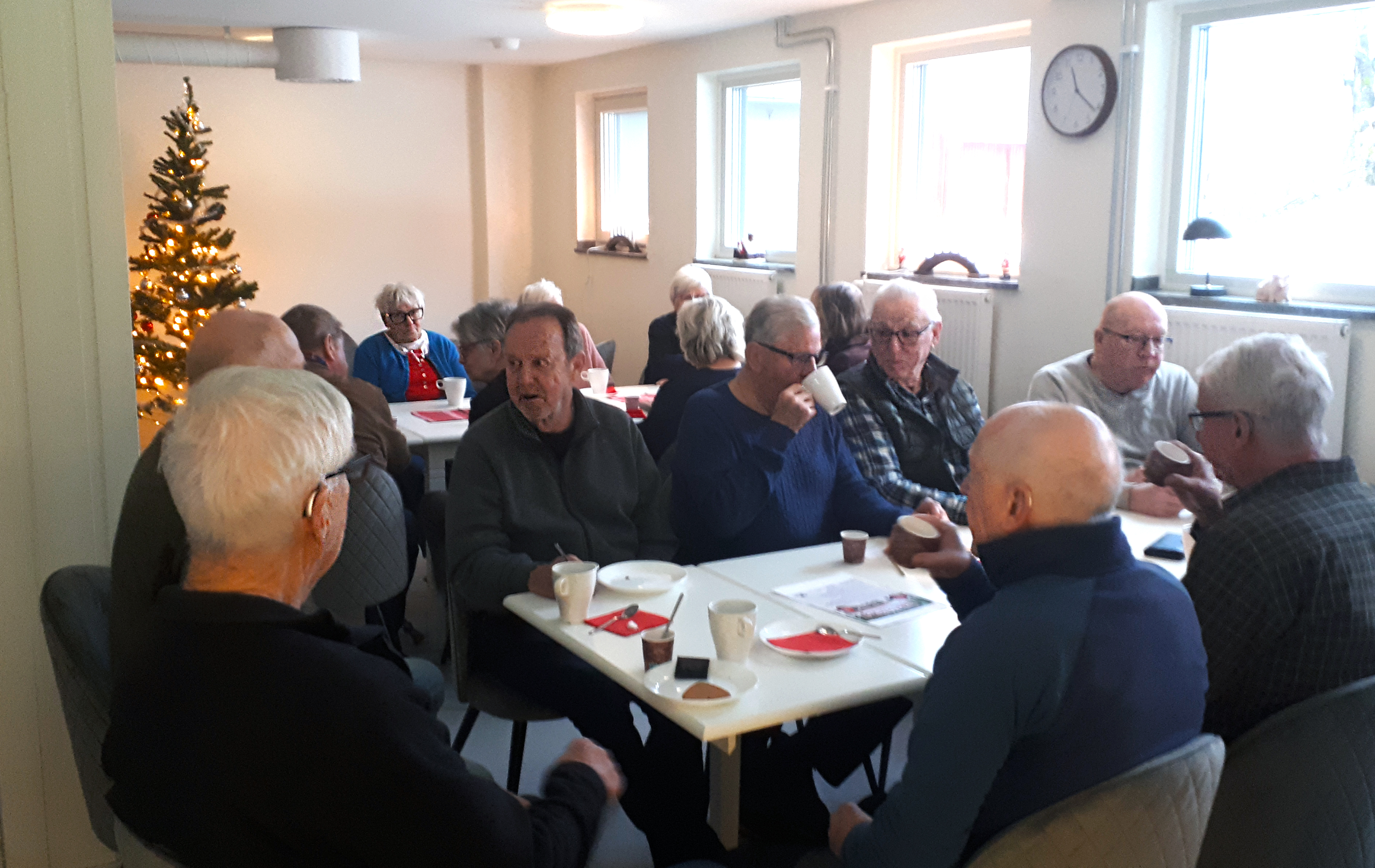 En bild av personer som sitter vid ett bord och fikar