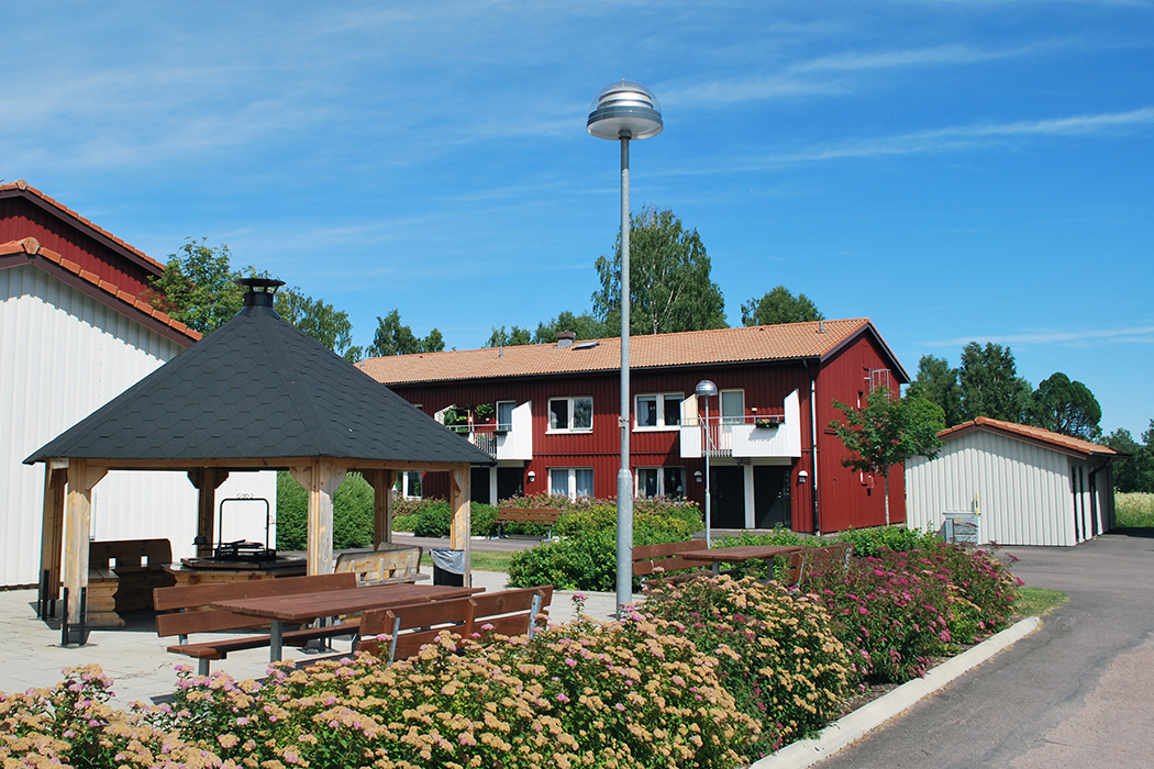 En bild av en huslänga bakom en grillplats